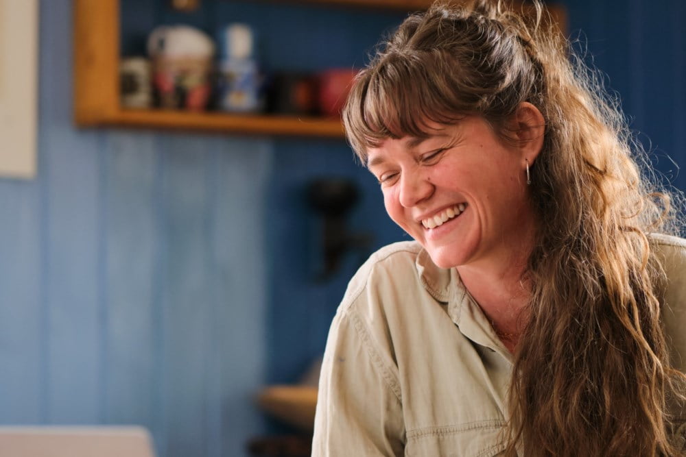 Dame som smiler foran PC