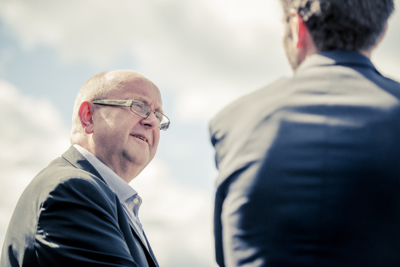 Mann ser mot høyre med ¨blikket åpent på en annen mann