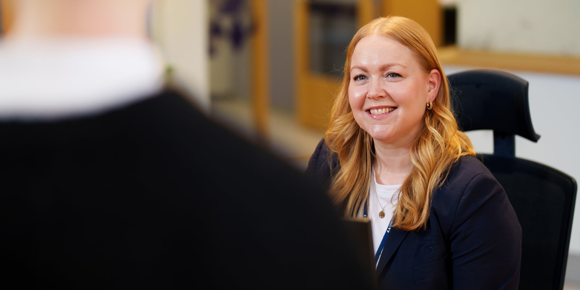 En smilende dame iført dress, hun joobber for Hegra Sparebank