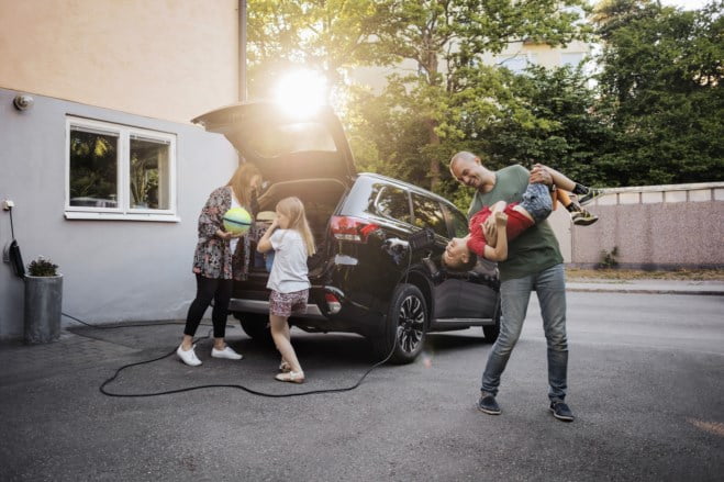 Familie tøyser ved elbilen sin